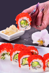 Sushi set compositionally located on a dark surface.