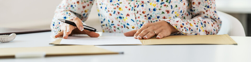 Secretary signing paperwork in a folder
