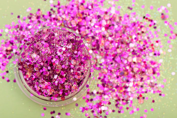 Pink glitter for nail design in small plastic box.