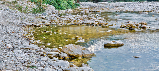 wide scenery of Italian rocky stream Mollarino in the end of the summer,hdr image