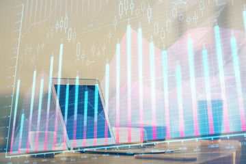 Stock market graph on background with desk and personal computer. Multi exposure. Concept of financial analysis.