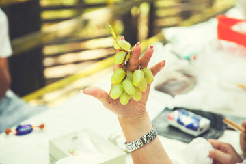 woman hand holding green grapes