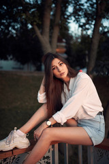 Beautiful young brunette in a summer park.