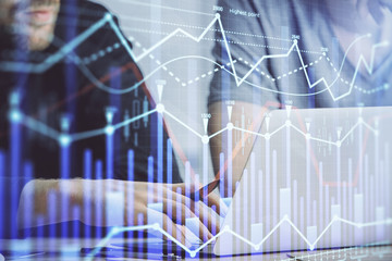 Forex graph with businessman typing on computer in office on background. Concept of analysis. Double exposure.