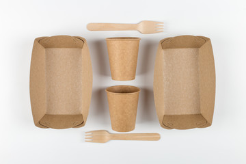 Ecological paper utensils, naturally decomposed materials. Plates, cups and wooden forks, a natural set for a picnic.