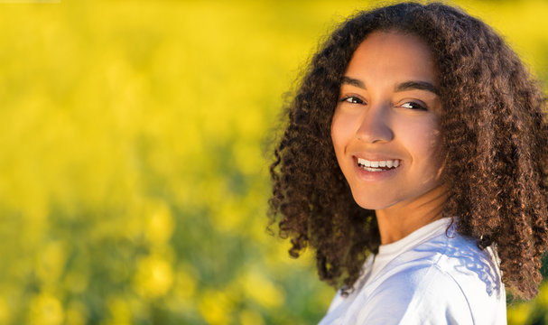 Happy Mixed Race African American Teenager Woman in Yellow Flowers