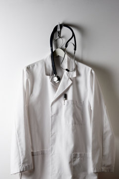 A Doctors White Lab Coat On A Hanger And Hook With Stethoscope.