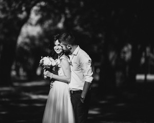 Bride and Groom at wedding Day walking Outdoors on spring nature. Bridal couple, Happy Newlywed woman and man embracing in green park. Loving wedding couple outdoor. 