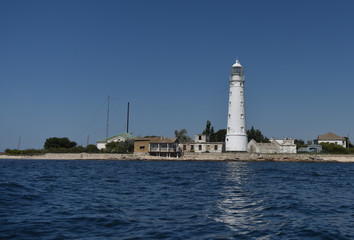 white lighthouse tower on the blue sea