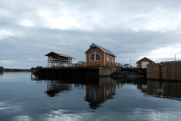 Fototapeta premium Norway rorbu houses and mountains rocks over fjord landscape scandinavian travel view Lofoten islands. Night landscape.