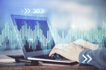 Double exposure of man's hands writing notes of stock market with forex graph background. Concept...