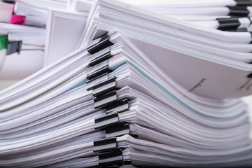 Stack of document paper with black paperclip.