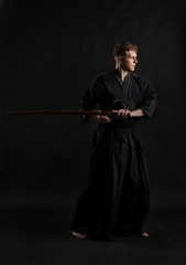 Kendo guru wearing in a traditional japanese kimono is practicing martial art with the shinai...
