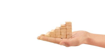 Wood block stacking as step stair with arrow up in hand. Ladder career path concept for business growth success process