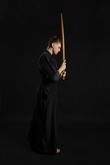Kendo guru wearing in a traditional japanese kimono is practicing martial art with the shinai...