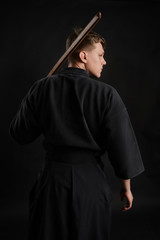 Kendo guru wearing in a traditional japanese kimono is practicing martial art with the shinai...