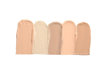 Samples of different foundation shades on white background, top view