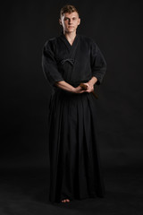 Kendo guru wearing in a traditional japanese kimono is practicing martial art with the shinai...