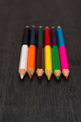 Colored pencils isolated on dark wooden background