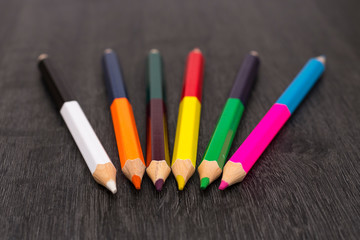 Colored pencils isolated on dark wooden background