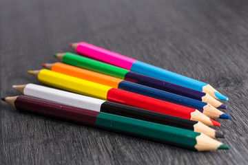 Colored pencils isolated on dark wooden background