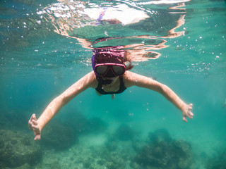 Underwater portrait of a woman snorkeling in tropical sea.