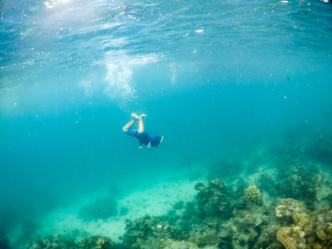 Underwater photo of man snorkeling in tropical sea.