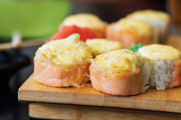 Hot rolls with ginger, wasabi and salmon on a wooden stand close-up