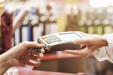 Buyer buys the goods in the store. Process of paying for goods with a plastic card, close-up