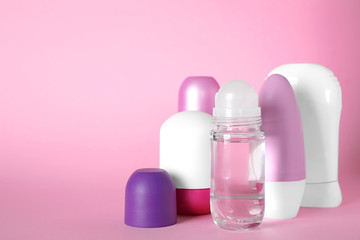 Set of different female deodorants on pink background
