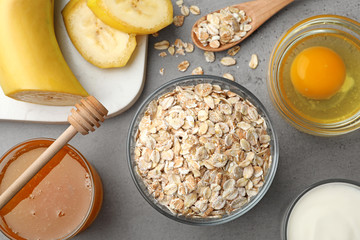 Different ingredients for handmade face mask on grey table, flat lay