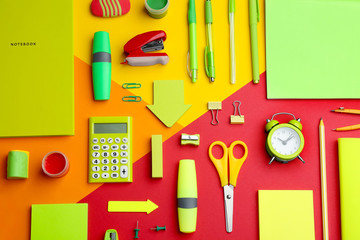 Different bright school stationery on color background, flat lay