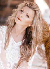 Portrait of beautiful young blonde woman with makeup  in white dress