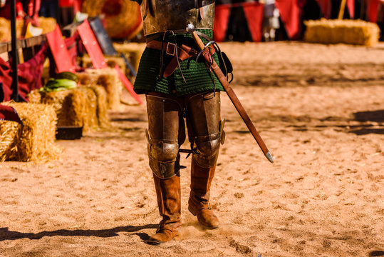Detail the armor and shield of an actor disguised as a medieval knight in a spring festival for children.