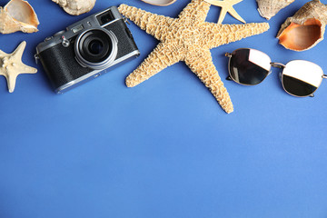 Flat lay composition with beach objects on blue background. Space for text