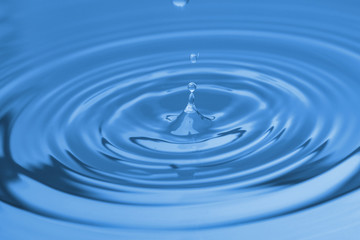 Splash of blue water with drop, closeup