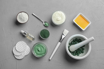 Fototapeta na wymiar Flat lay composition with spirulina facial mask and ingredients on light grey table