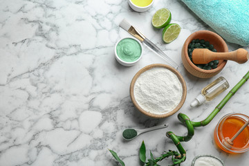 Flat lay composition with spirulina facial mask and ingredients on marble table, space for text