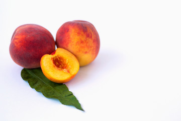 fresh peaches with leaves isolated on white background
