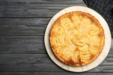 Delicious sweet pear tart on dark wooden table, top view. Space for text