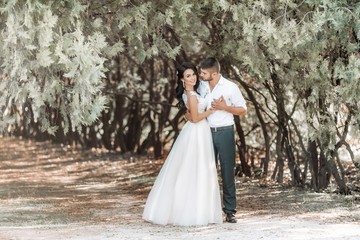 Bride and Groom at wedding Day walking Outdoors on spring nature. Bridal couple, Happy Newlywed woman and man embracing in green park. Loving wedding couple outdoor. 