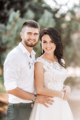 Obraz premium Bride and Groom at wedding Day walking Outdoors on spring nature. Bridal couple, Happy Newlywed woman and man embracing in green park. Loving wedding couple outdoor. 