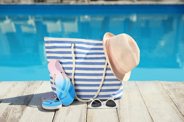 Beach accessories on wooden deck near outdoor swimming pool
