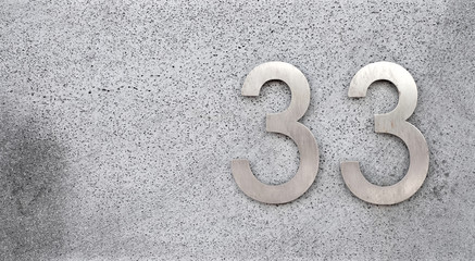 33, number thirty-three, elegant silver metalic digits on gray surface, offset with copy space.