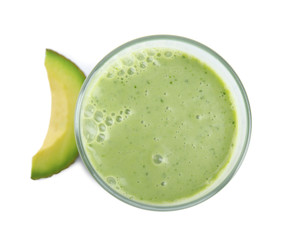 Glass of tasty smoothie and avocado slice on white background, top view