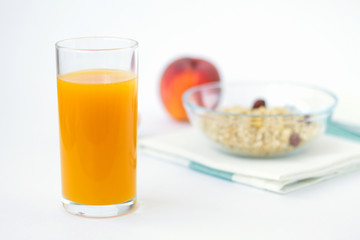 glass of peach juice and fresh fruits on white table