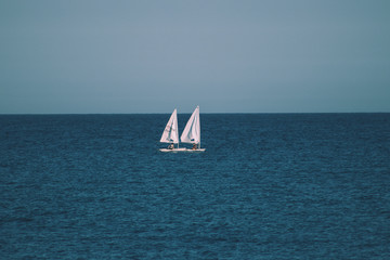 two small sailboats in the open sea