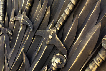 Swords background. Piles of ancient bronze cold weapon close up view. Backdrop decoration in...