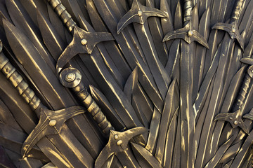 Swords background. Piles of ancient bronze cold weapon close up view. Backdrop decoration in medieval style. Kings, knights and warrior ammunition elements