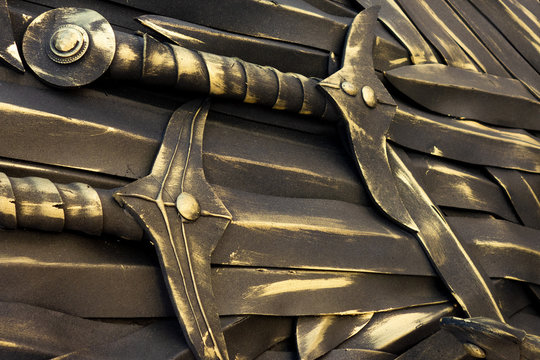 Swords background. Piles of ancient bronze cold weapon close up view. Backdrop decoration in medieval style. Kings, knights and warrior ammunition elements